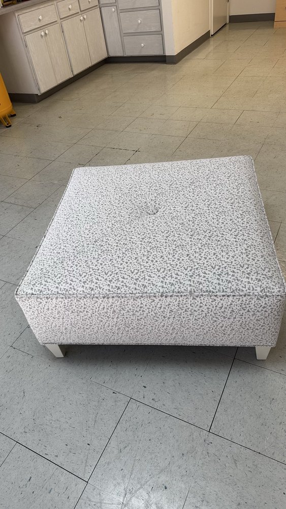 Large square ottoman upholstered in textured grey boucle