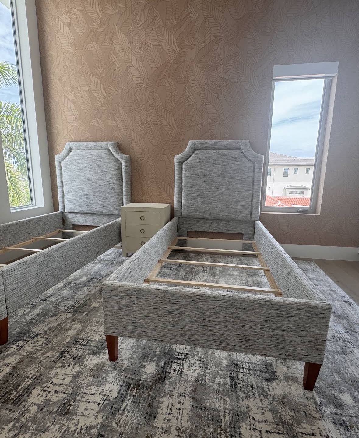 Custom upholstered twin bed frames with grey chenille fabric in a Sarasota bedroom