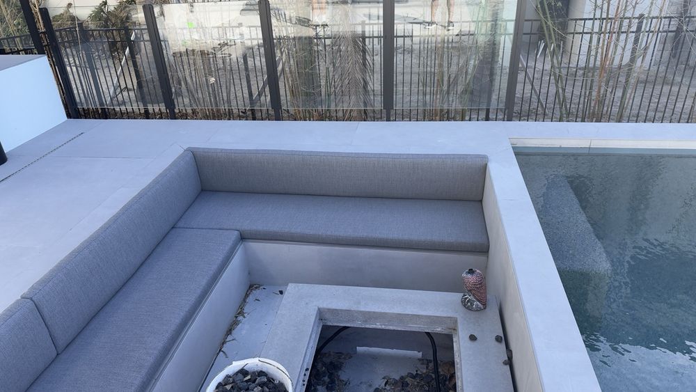 Built-in poolside seating upholstered in grey outdoor fabric